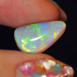 Natural dark opal Lightning Ridge closeup showing vivid green and yellow flashes across the face.