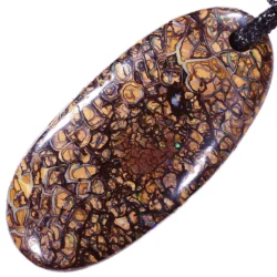 Close-up of boulder opal pendant showing vivid green and blue color play in koroit pattern