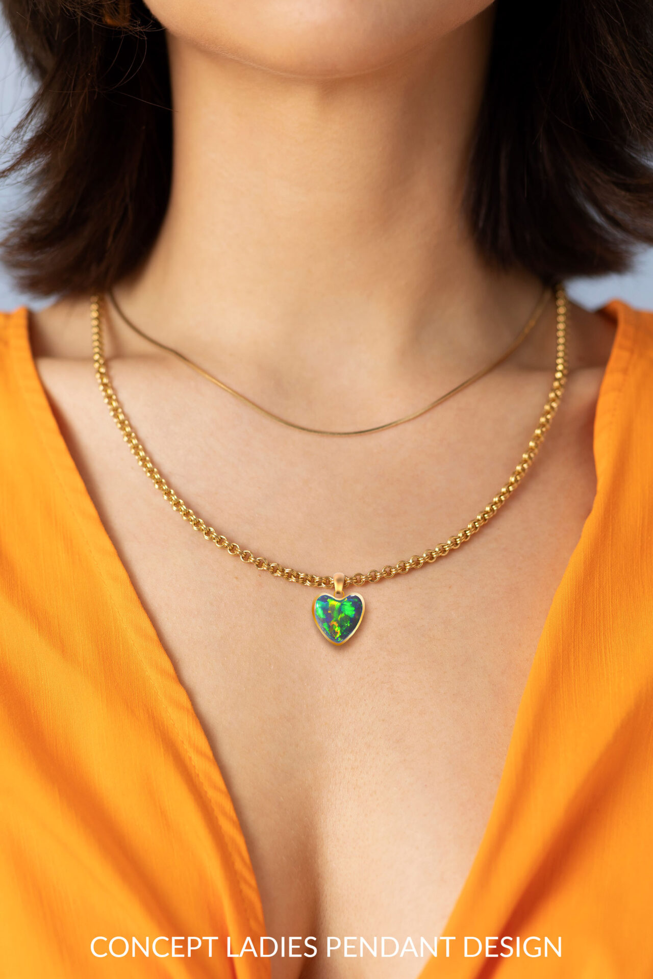 2.14ct natural black opal heart pendant worn on necklace showing bright green fire
