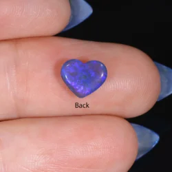 Back view of a 0.8ct natural black crystal opal heart cabochon showing blue and violet colour play, Lightning Ridge Australia