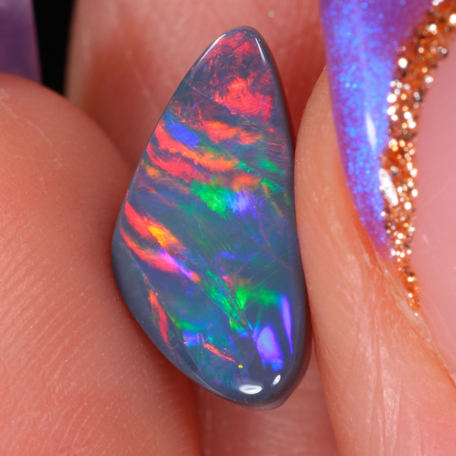 1.8ct Natural Black Opal -Rainbow Rolling Ribbon Pattern-hand shot