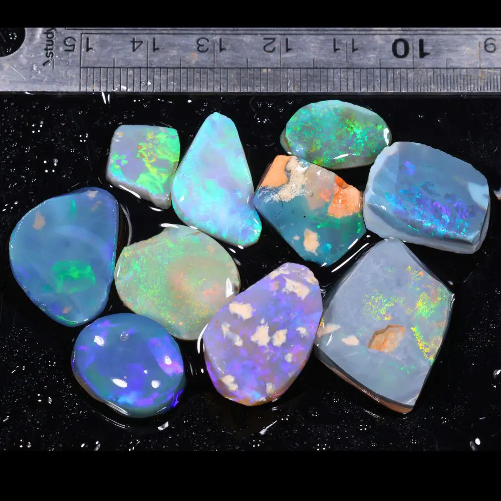 Lightning Ridge opal rubs parcel showing bright green and blue fire with ruler for size reference