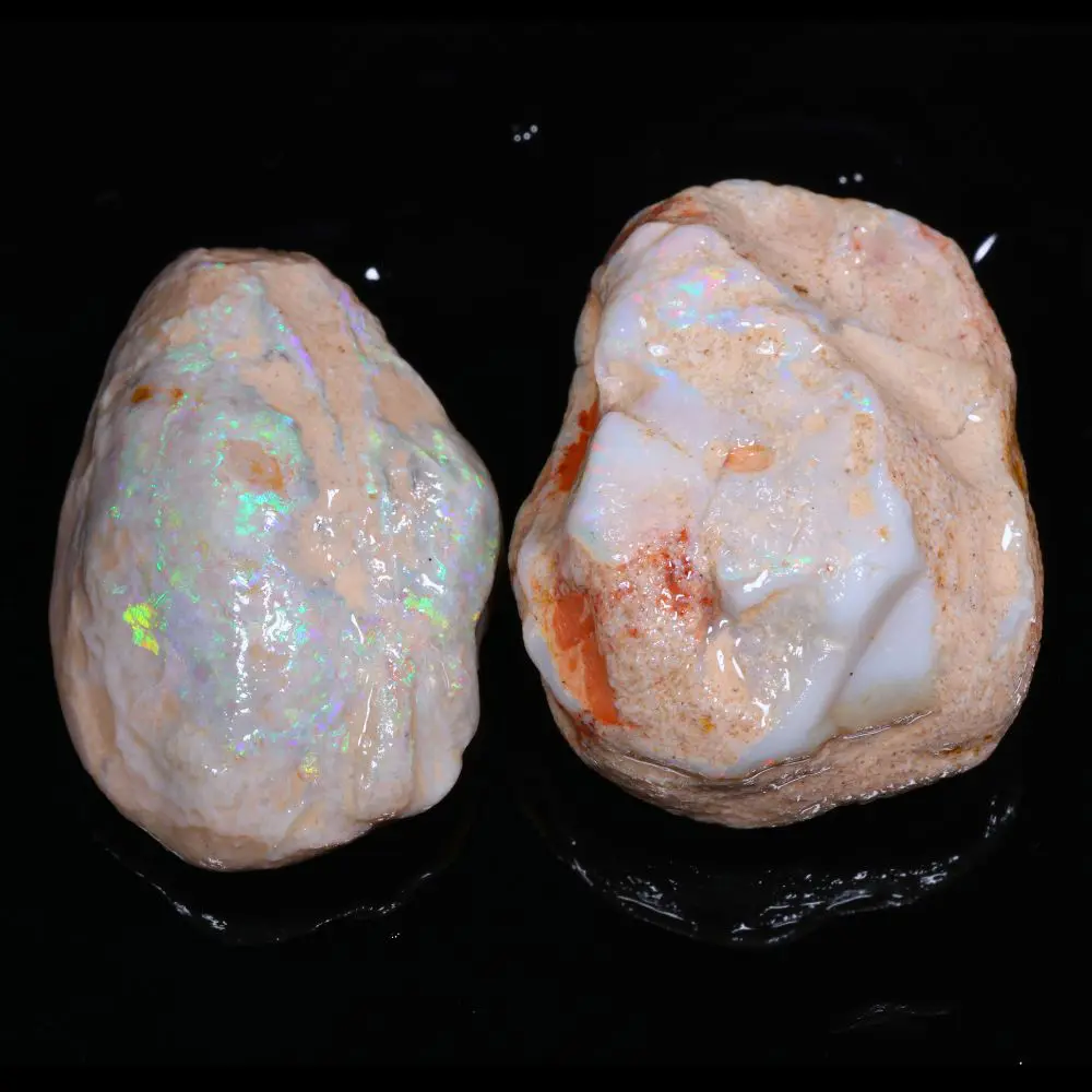 Two Lightning Ridge shell opal rough stones showing white opal base with green flashes and ruler for size reference