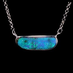29.7ct Australian boulder opal pendant displaying intense deep blue and green ocean tones in a horizontal silver bezel setting. Natural untreated opal.