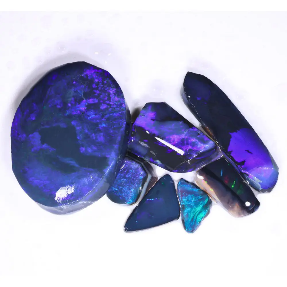 Lightning Ridge black opal rubs parcel showing deep blue and purple fire with ruler for size reference