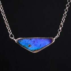 Boulder opal pendant with purplish blue fire shown on black background 25.6ct triangular shape horizontal style natural Australian opal.