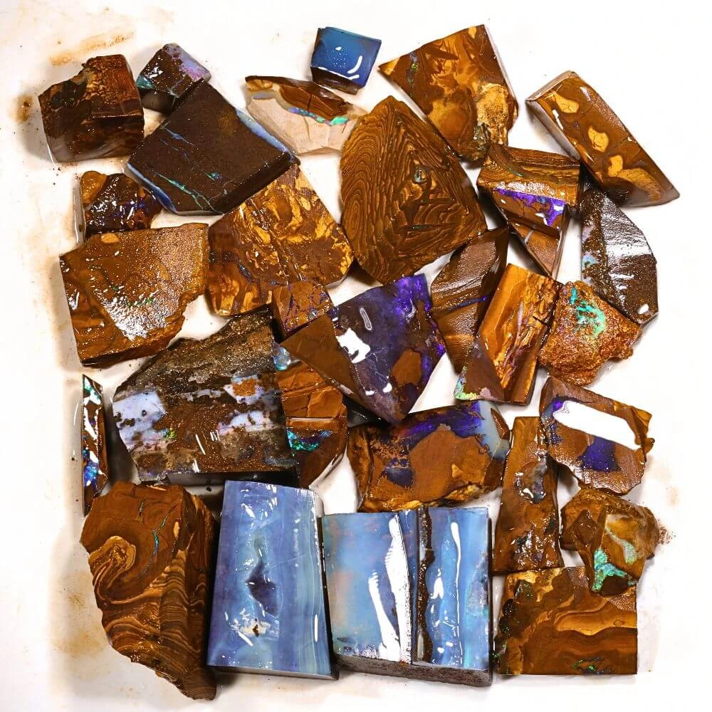 437g boulder opal rubs rough parcel of 30 pieces from Winton, Australia with purple, blue, and teal fire through natural ironstone matrix. Natural, untreated beginners parcel.