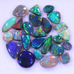 15ct Lightning Ridge opal jewelers parcel of 25 polished cabochons from Australia with green, red, blue, and purple fire. Mix of black, dark, and crystal opals. Natural, untreated.