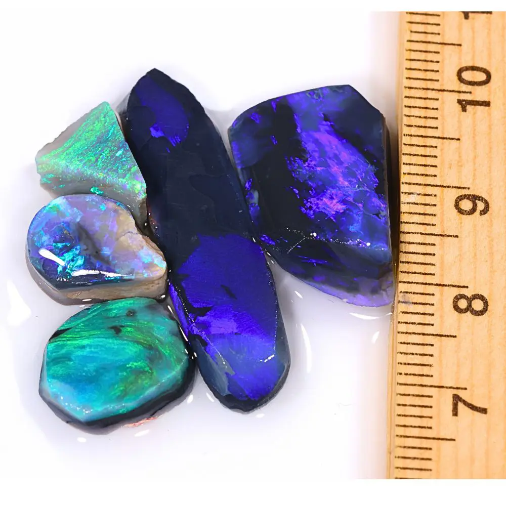 38ct Lightning Ridge black opal rubs parcel from Australia showing deep blue and purple fire on larger pieces with vivid green and teal fire on smaller stones. 100% natural and untreated.