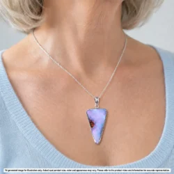 Natural pink boulder opal pendant with orange color and ironstone matrix shown worn on a silver chain