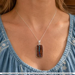 Natural Australian boulder opal pendant shown worn on a silver chain with purple green opal seam and rectangular hand carved matrix