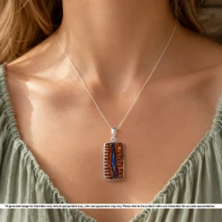Natural purple blue Australian boulder opal pendant shown worn on a silver chain with rectangular hand carved ironstone matrix