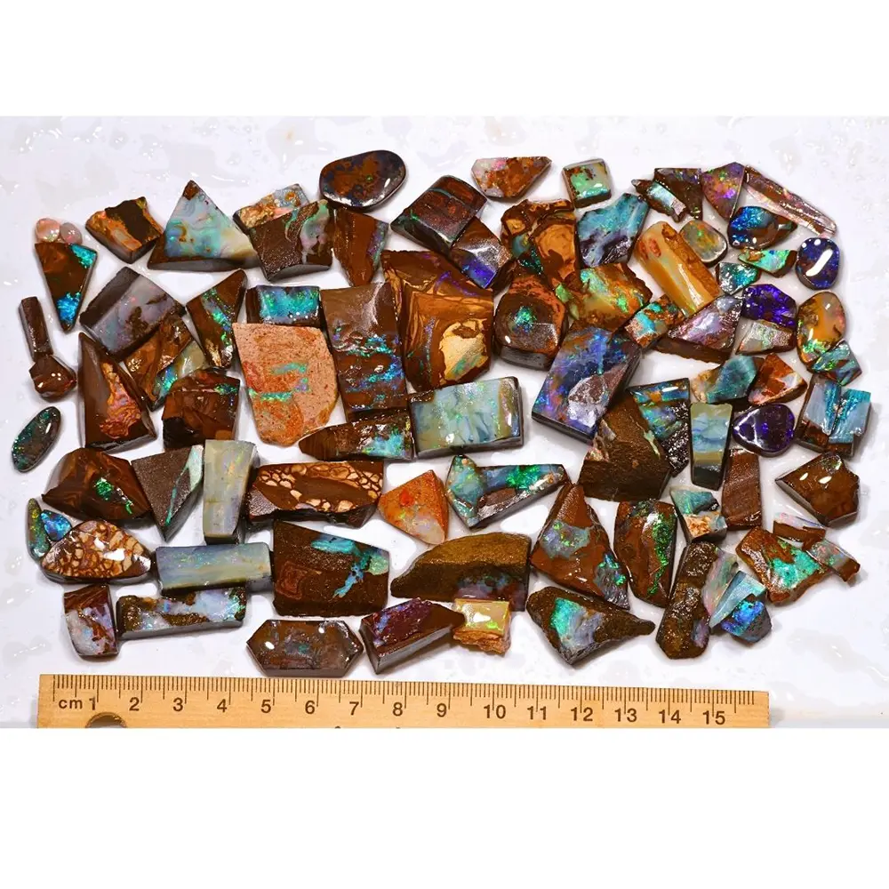 315g Boulder Opal rubs from Winton Australia showing 85 natural ringstone sized pieces with a ruler for size reference
