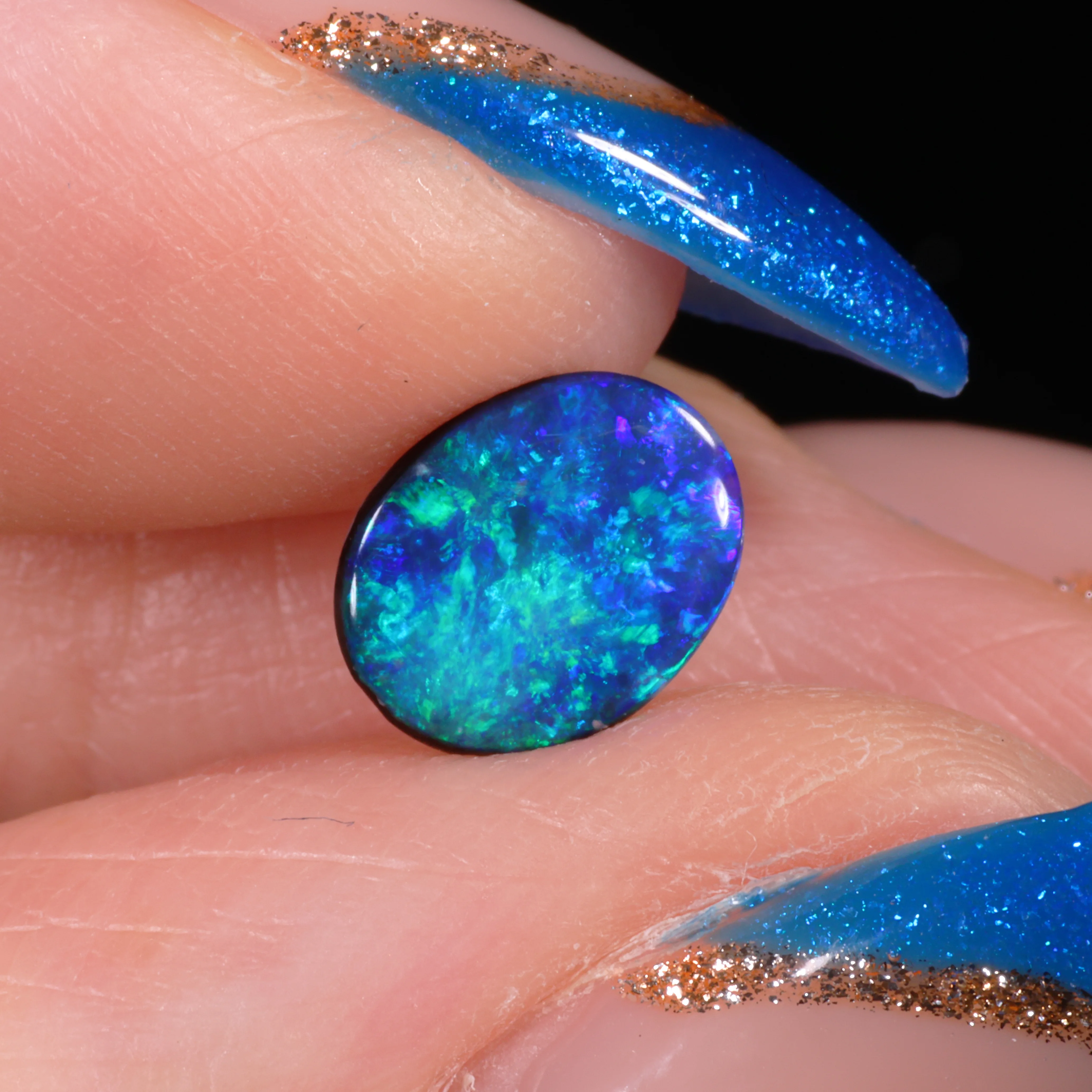 calibrated-black-opal-oval-ring-stone-finger-display-0-63ct-opal-galaxy