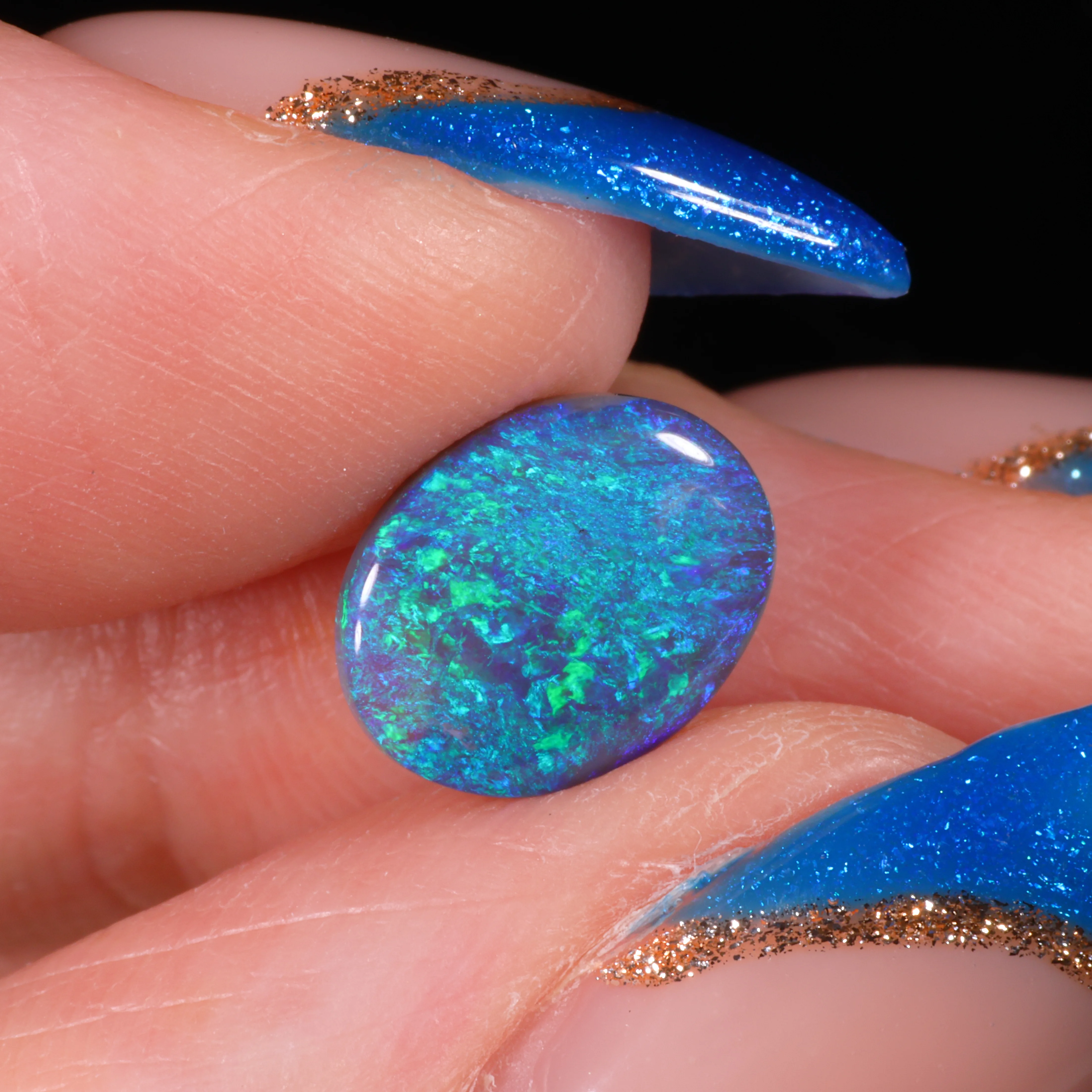 natural-black-opal-oval-on-finger-display-1-8ct-opal-galaxy