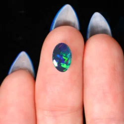 natural-lightning-ridge-black-opal-cabochon-on-hand-0-87ct-opal-galaxy