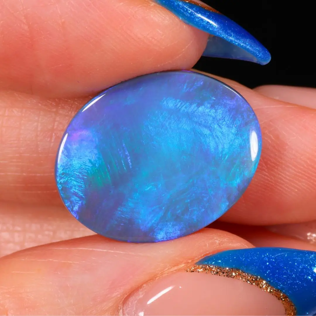 Lightning Ridge black opal oval showing bright ocean blue and green color close up view