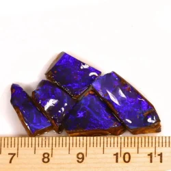 Five natural Winton Boulder Opal rubs weighing 11 grams displaying intense electric purple and violet blue colors beside a ruler for size reference.