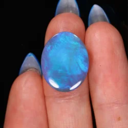 6.87ct Australian black opal from Wee Warra Lightning Ridge shown on hand for scale