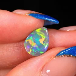 Natural Lightning Ridge dark opal 1.66ct teardrop gemstone showing vivid green, orange, yellow and blue rainbow flashes in a close up hand view.
