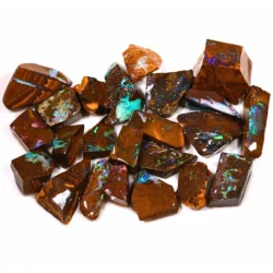 Detailed view of natural Boulder Opal ringstone rough featuring bright turquoise and green opal patches, purple flashes and earthy brown ironstone matrix for gemstone cutting.