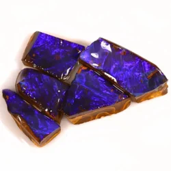 Close up of five Australian Boulder Opal ringstone rubs showing vivid electric purple play of color with natural brown ironstone backing.