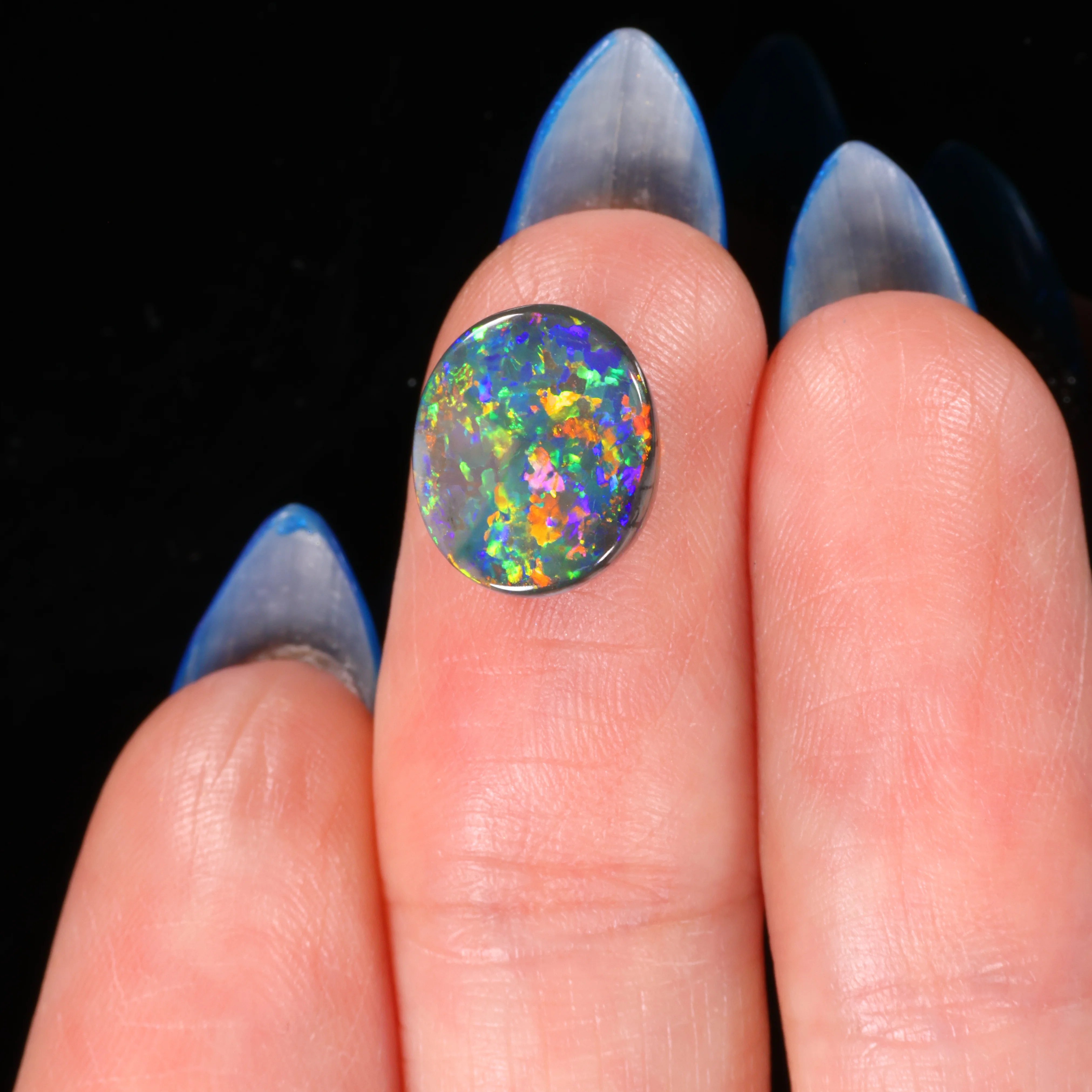 natural black opal oval on finger scale display 2 83ct opal galaxy