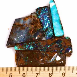 Five natural Winton Boulder Opal rubs weighing 31 grams displaying electric blue, turquoise, green and purple colors beside a ruler for size reference.